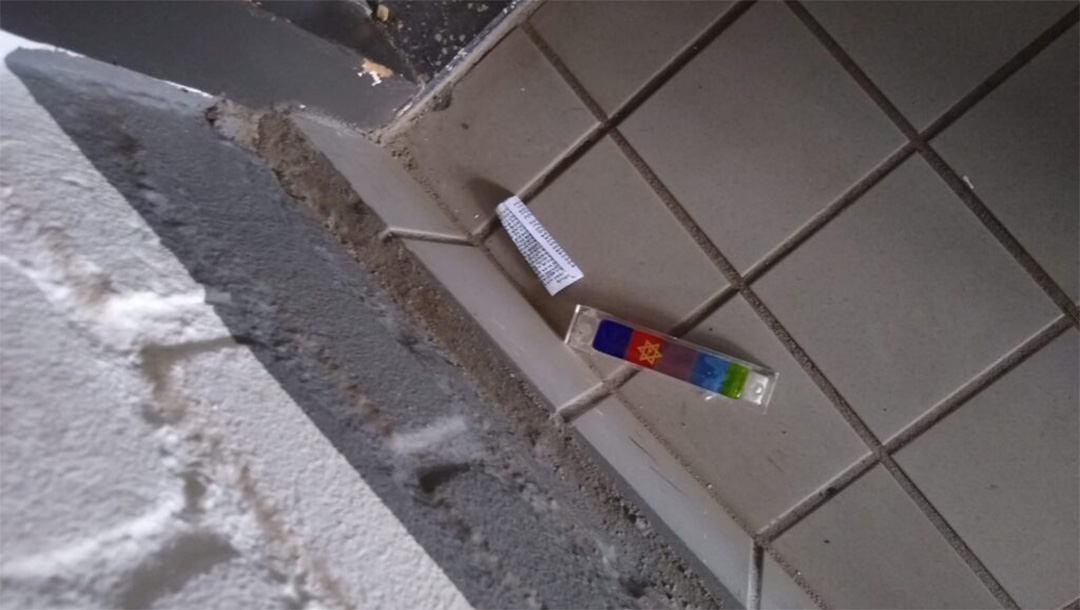 A vandalized mezuzah lies on the floor at the entrance to a Jewish student's home in Maastricht, the Netherlands on Feb. 18, 2021. (Stand With Us Netherlands)