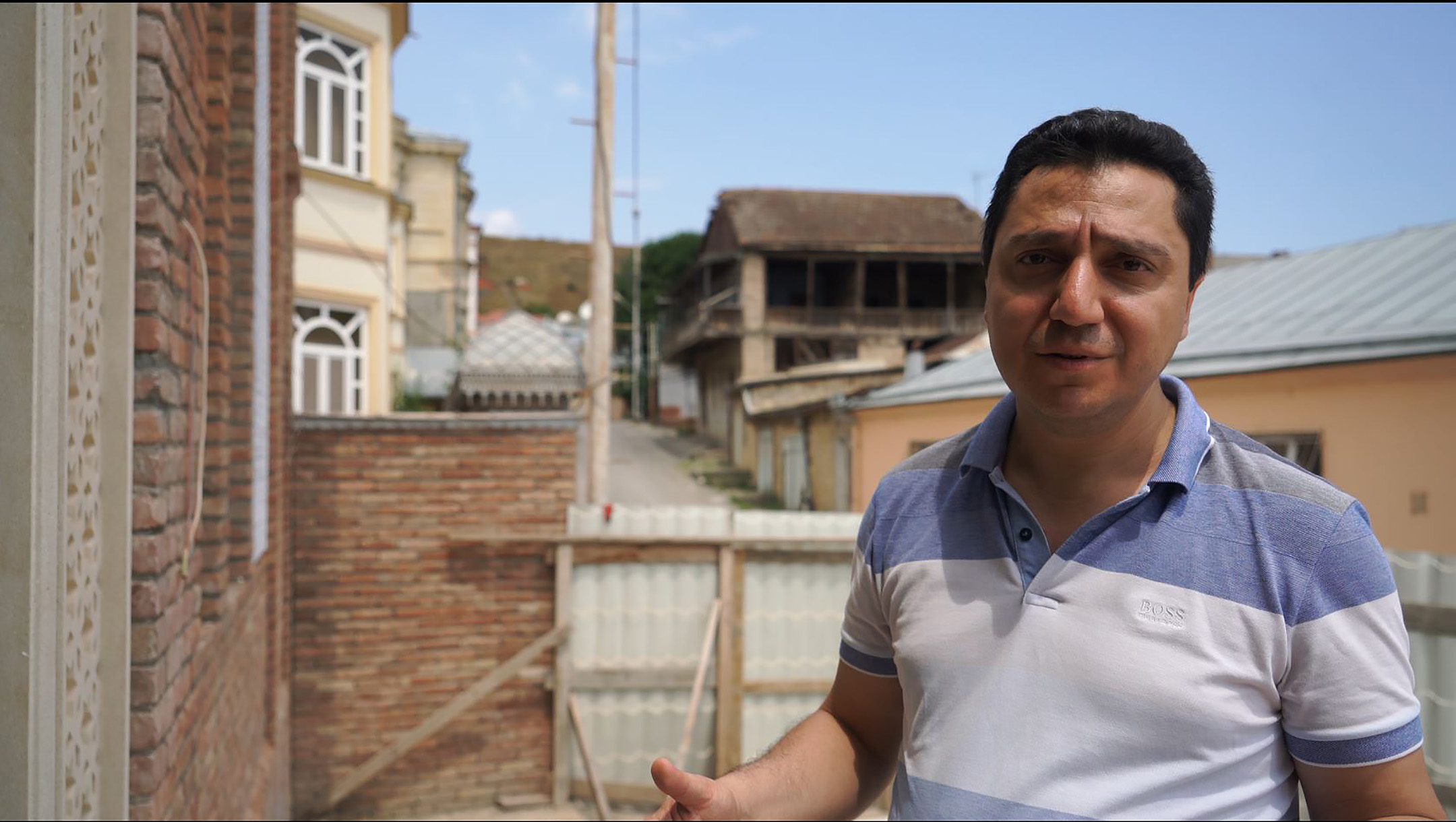 David Mordechayev stands outside the soon-to-be-opened Mountain Jews museum in Krasnaiya Sloboda, July 21, 2018. (Cnaan Liphshiz)