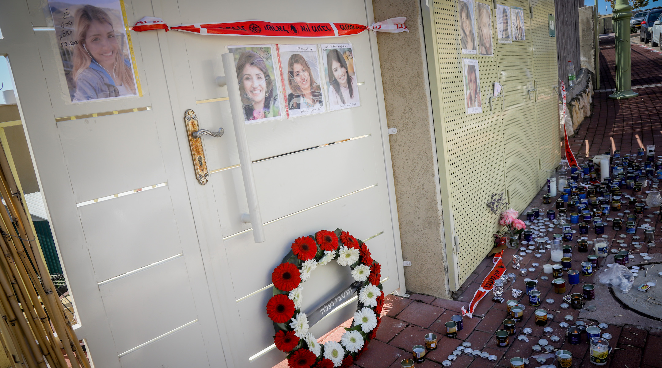 Candles sit beside pictures of Diana Raz outside her home in the West Bank settlement of Na’ale on February 7, 2021. (Avi Dishi/Flash90)