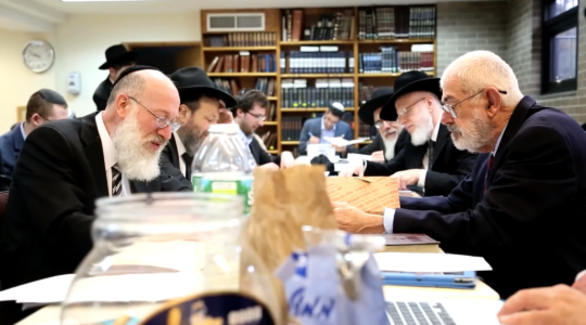 Rabbi Mordechai Willig, left, executes the 2015 sale of hametz to John Brown, right. Brown died this year after decades of buying hametz from thousands of American Jews each year before Passover. (Josh Weinberg/screen shot from YouTube)
