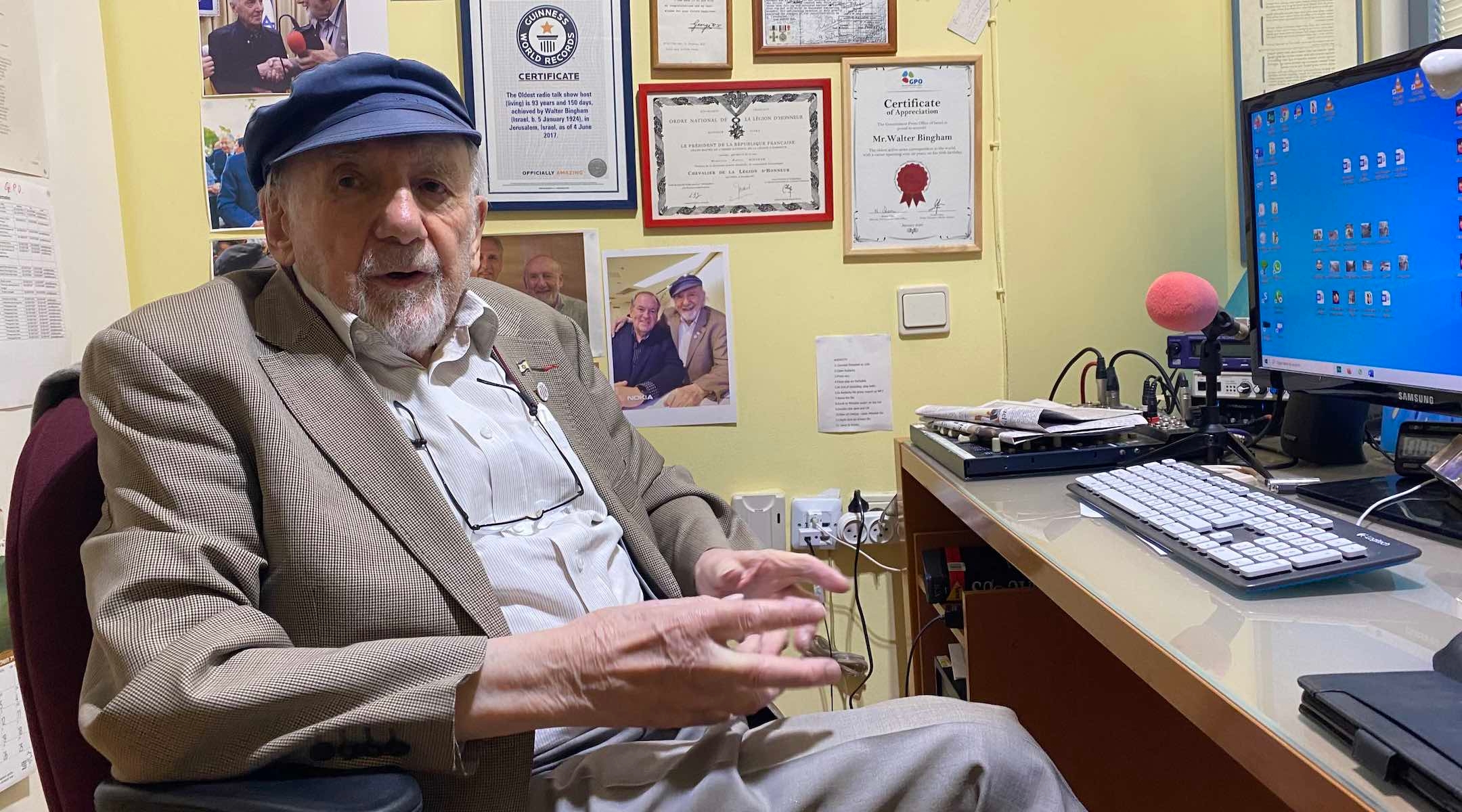 Walter Bingham, a 97-year-old radio journalist, sitting in his office behind a wall filled with memorabilia, including a telegram regarding an award he won from the United Kingdom's King George VI. (Sam Sokol)