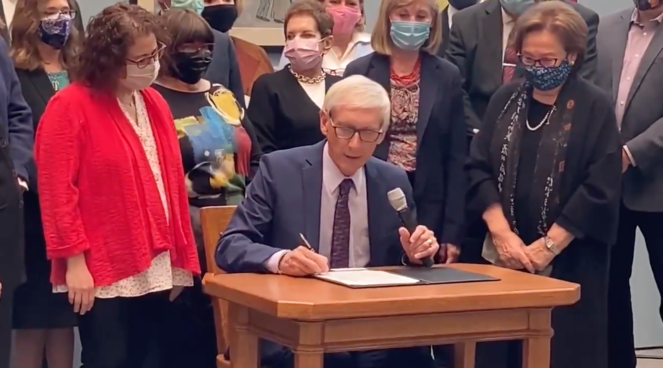 Wisconsin Gov. Tony Evers signs a bill mandating Holocaust education starting in fifth grade. (Screenshot from Twitter)
