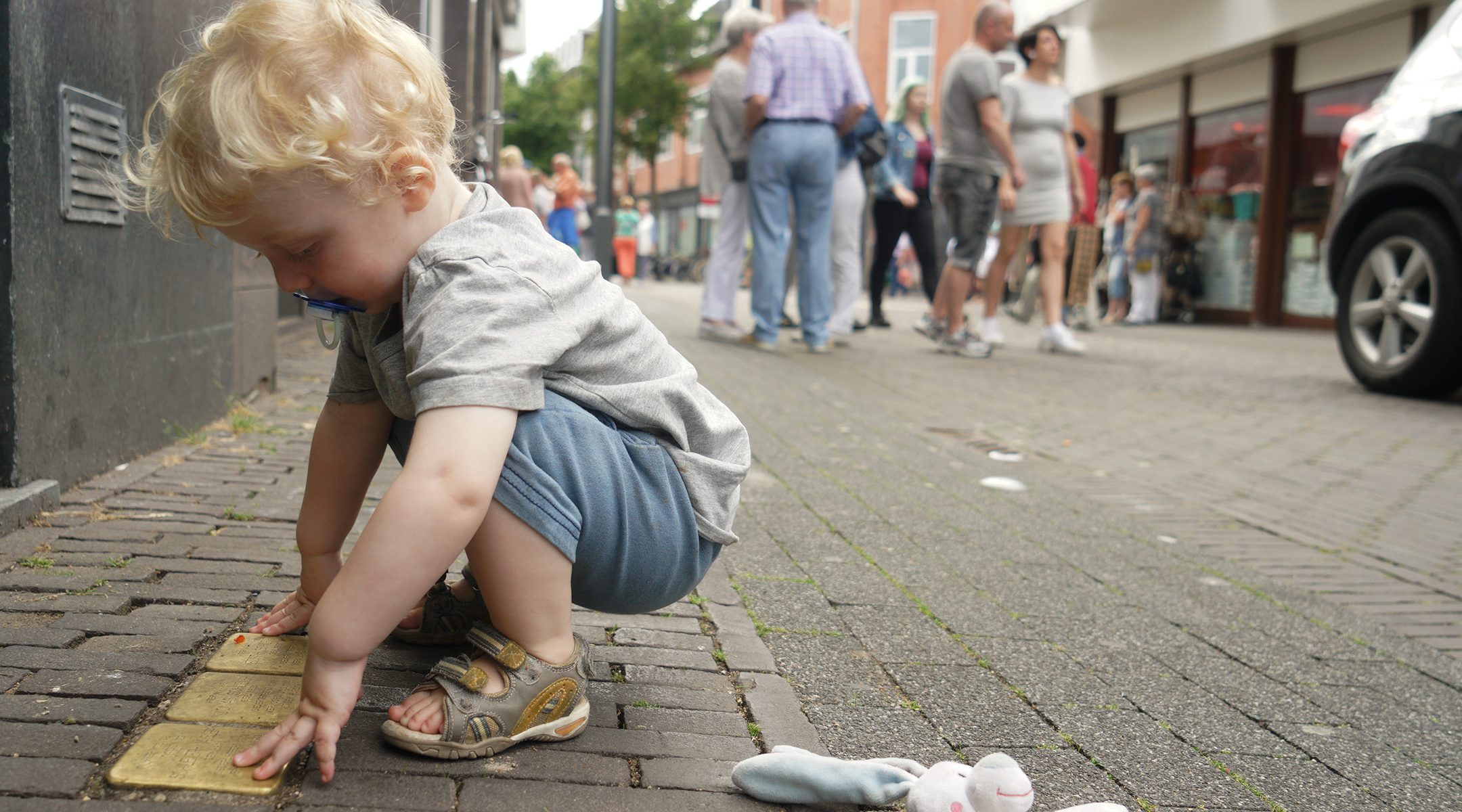The son of JTA's Europe correspondent pictures here when he was nearing his 2nd birthday, examines a memorial cobblestone for murdered Dutch Jews in Heerlen, the Netherlands on July 29, 2017. (Cnaan Liphshiz)