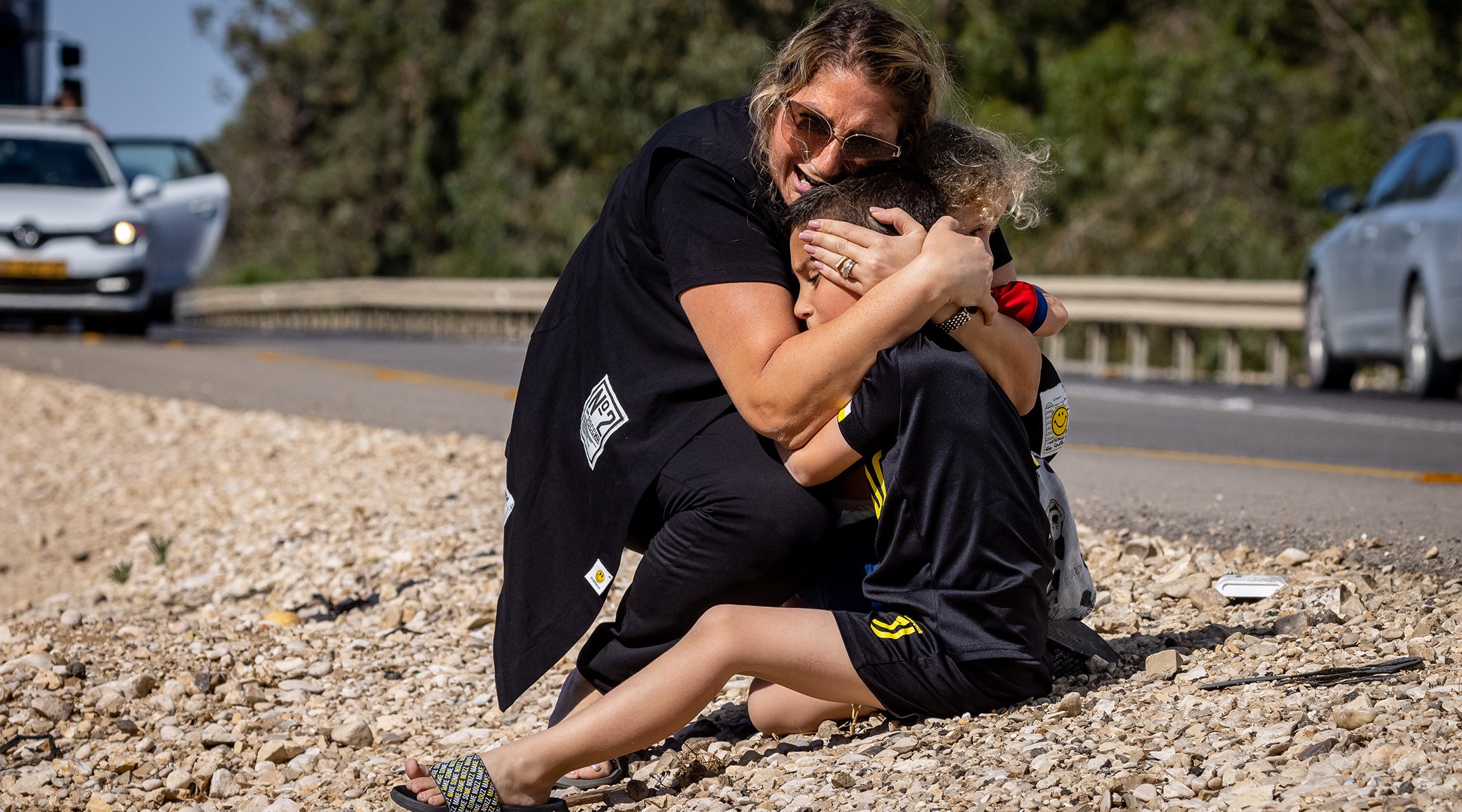 A woman and child take cover as a siren sounds a warning of incoming rockets fired from the Gaza strip on a road between Ashkelon and Sderot, southern Israel, on May 19, 2021.(Olivier Fitoussi/Flash90)