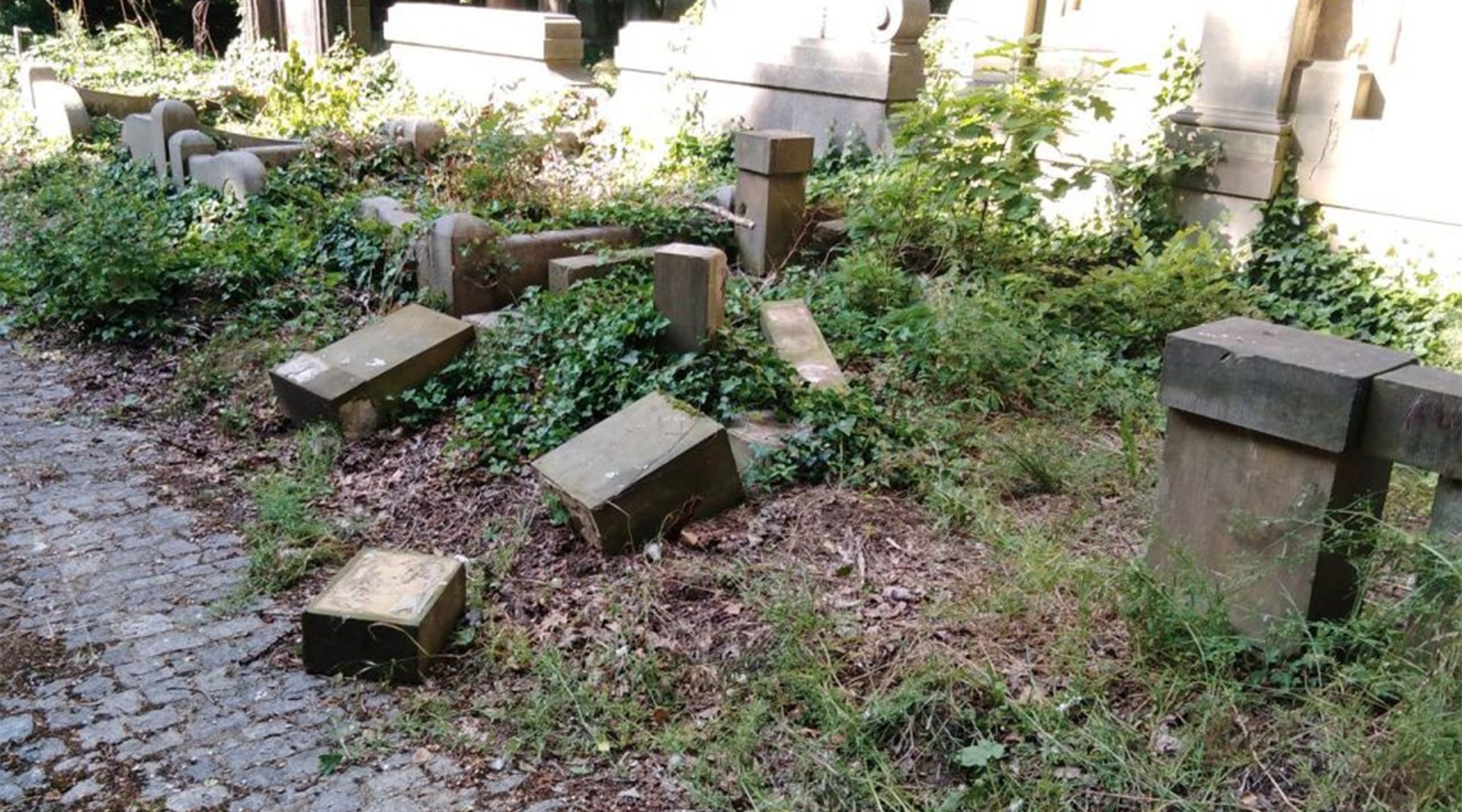 Toppled and smashed headstone lie scattered at the Jewish Cemetery of Wroclaw, Poland on June 16, 2021. (The Jewish Community of Wroclaw)