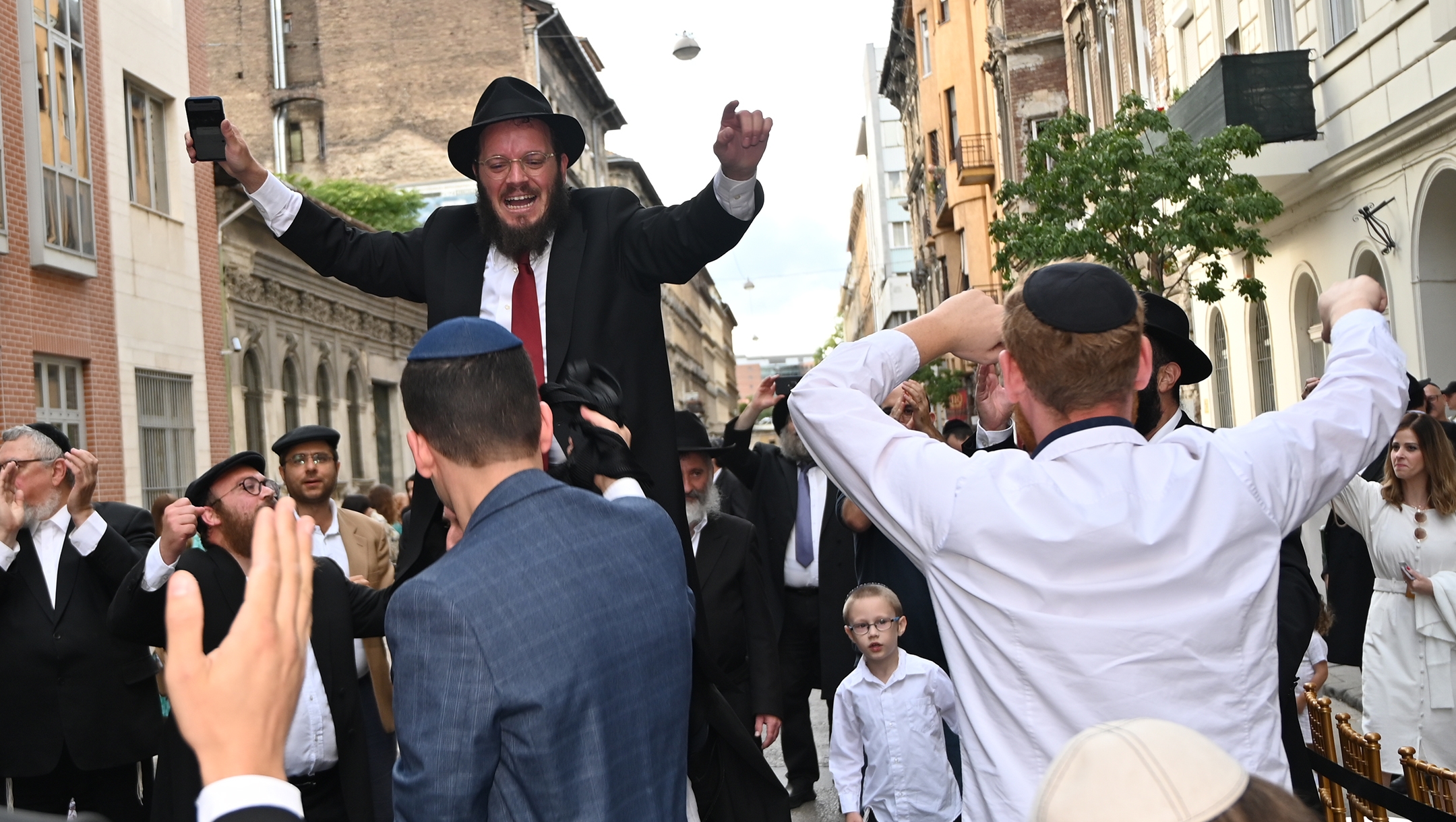 Rabbi Shmulik Oirechman dancing on the shoulders of other Jews at the opening of the Vorosmarty Street Synagogue in Budapest, Hungary on Aug. 27, 2021. (Cnaan Liphshiz)