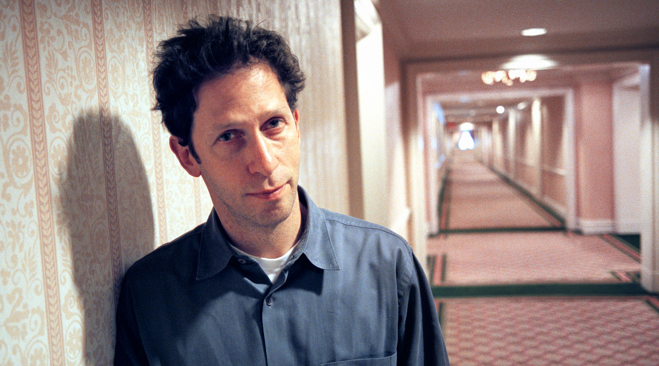 Tim Blake Nelson in a hotel hallway