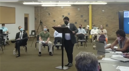 A rabbi speaks at a city council meeting