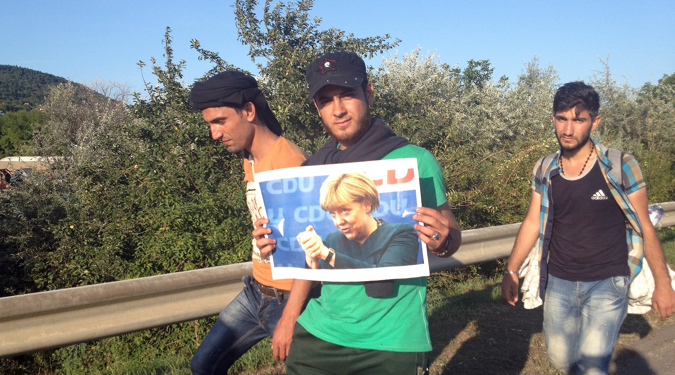 Syrian refugees carry a photograph of Angela Merkel 