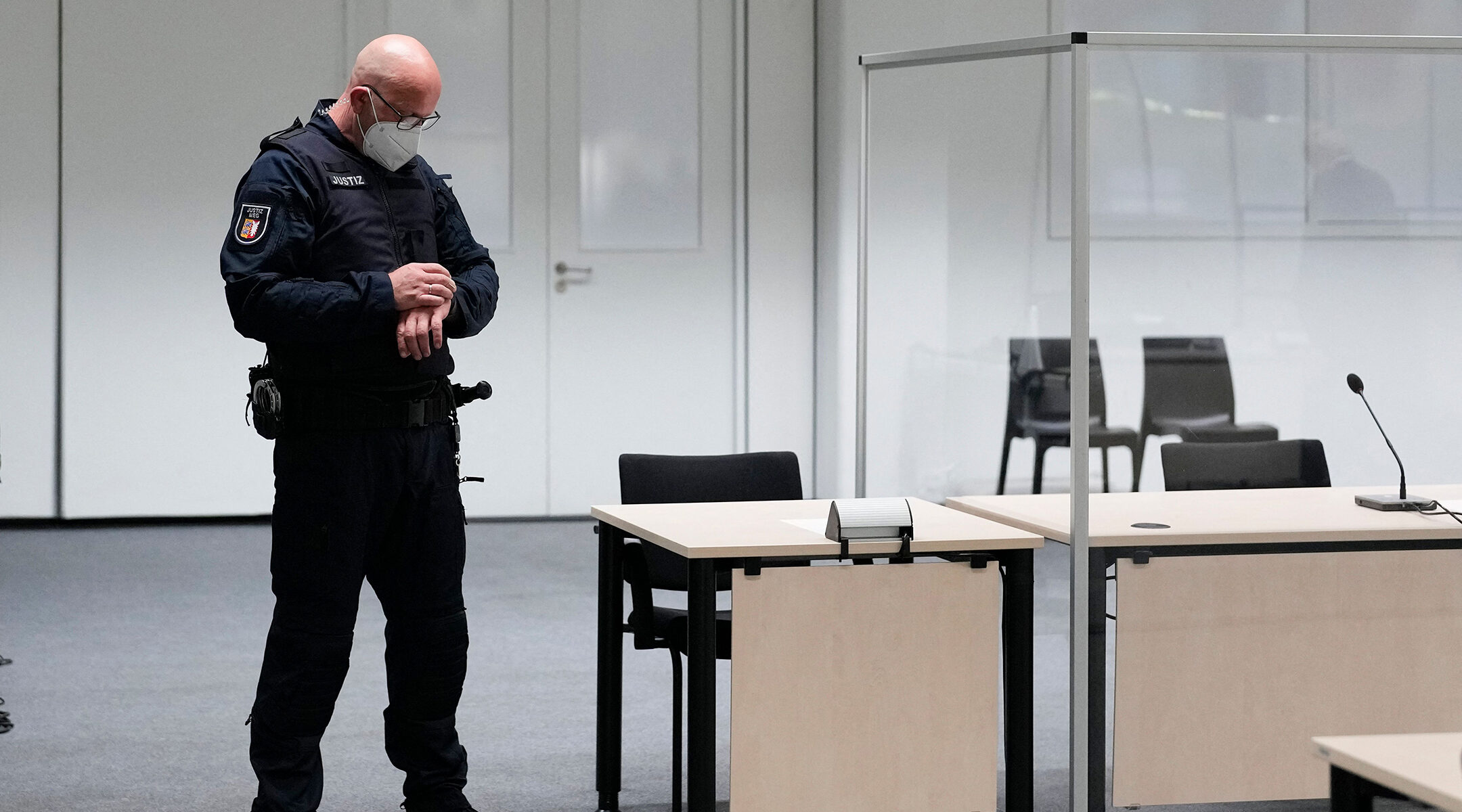 A judicial officer looks at his watch prior to a trial against 96-year-old alleged war criminal Irmgard Furchner in Itzehoe, Germany, on Sept. 30, 2021. (Markus Schreiber/Pool/AFP via Getty Images)