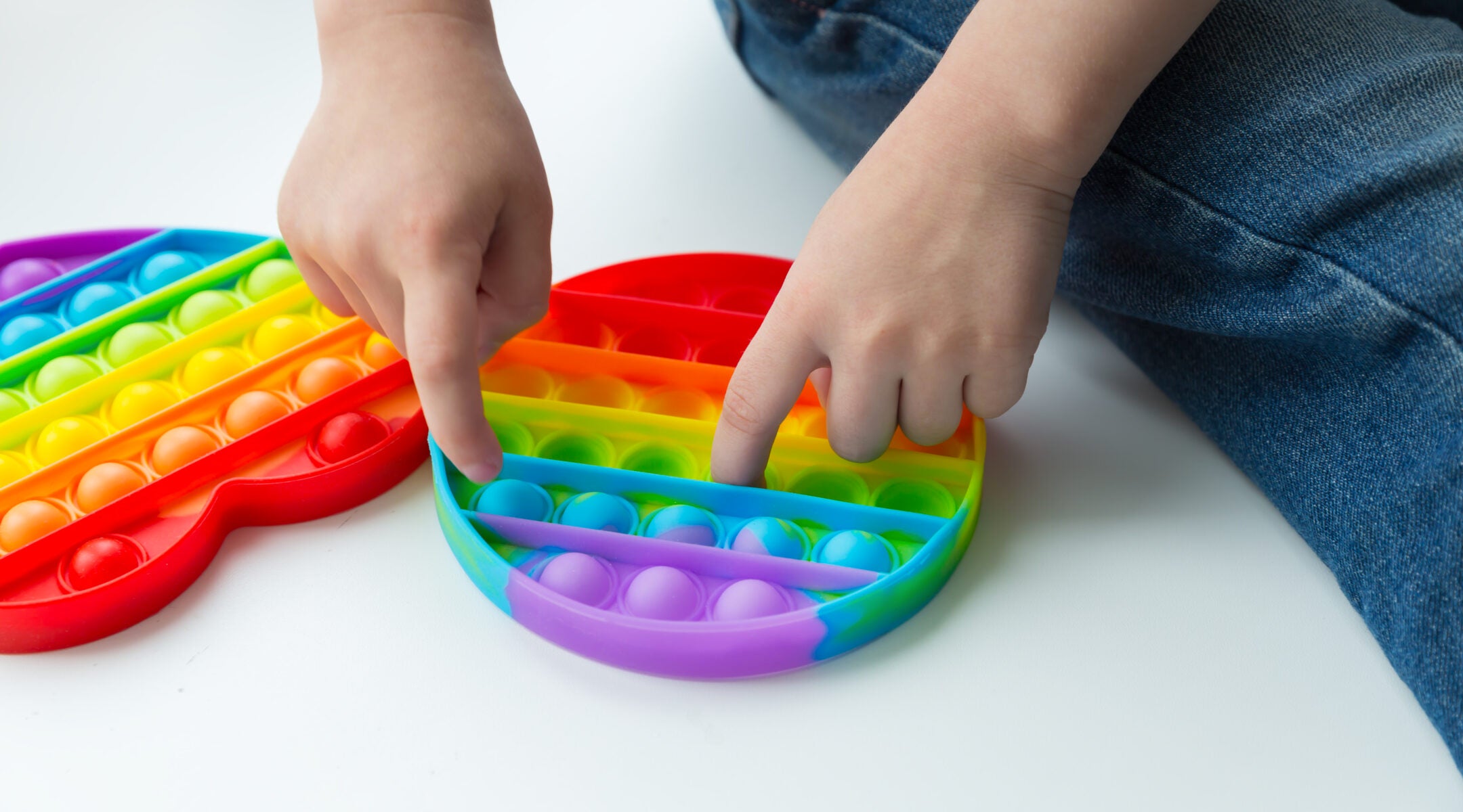 Childs Hands Playing With Colorful Poppit Game Pop It Fidget Toy