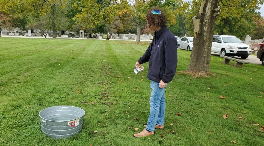 A man pouring water in a park