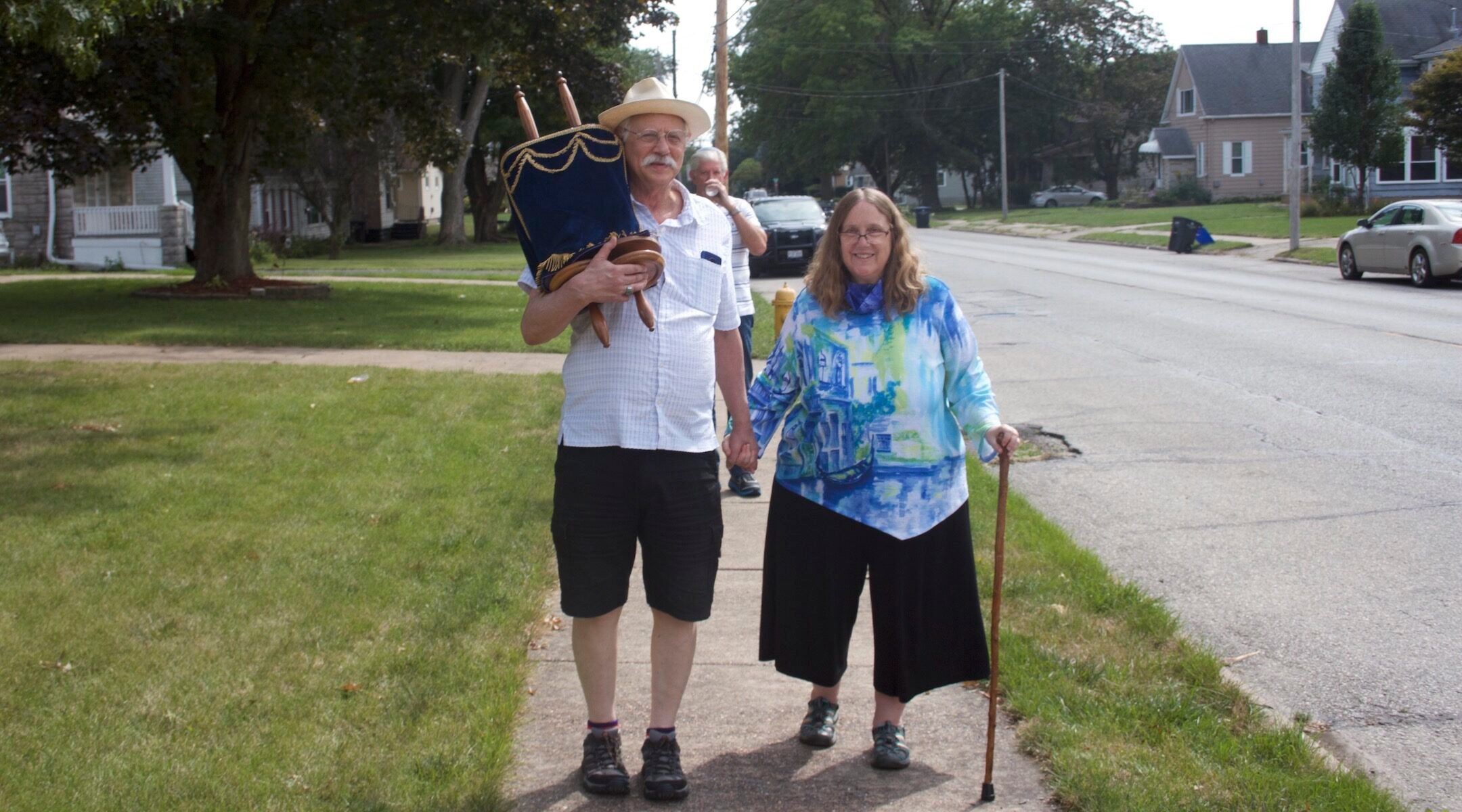 A rabbi and her husband carry a Torah