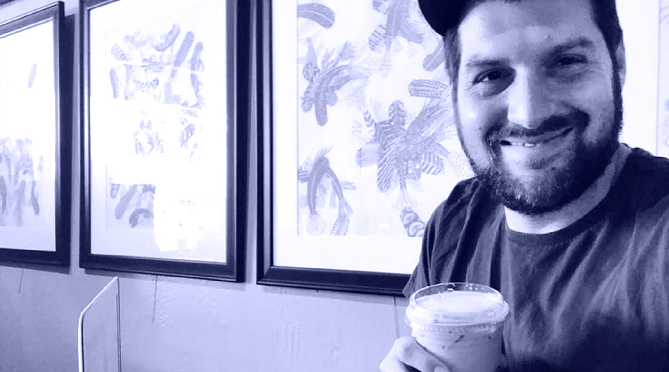 A man poses for a selfie with a coffee cup