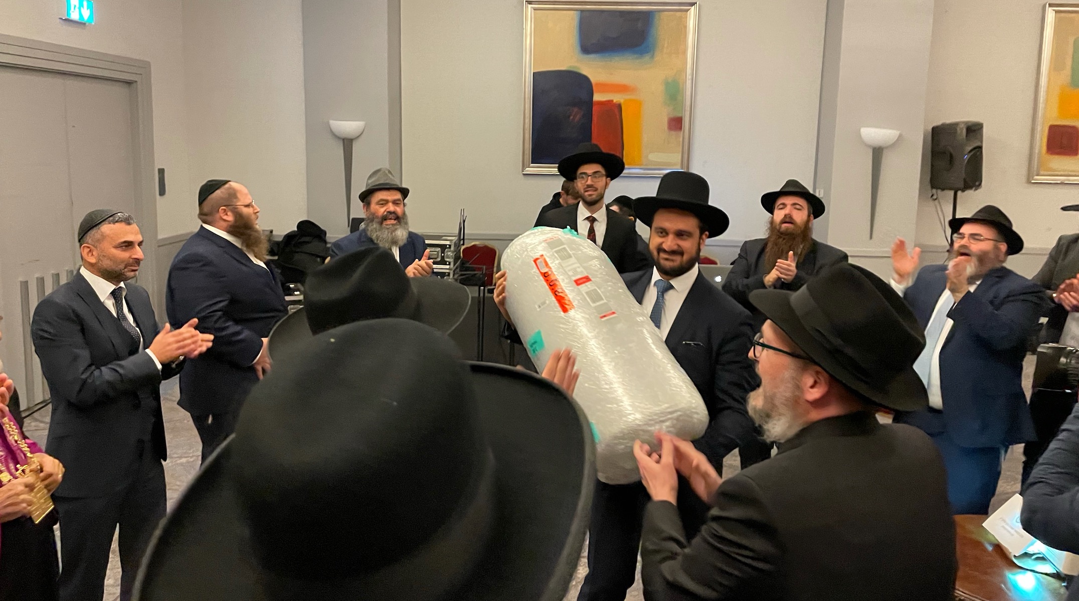 A group of rabbis dancing in a conference room