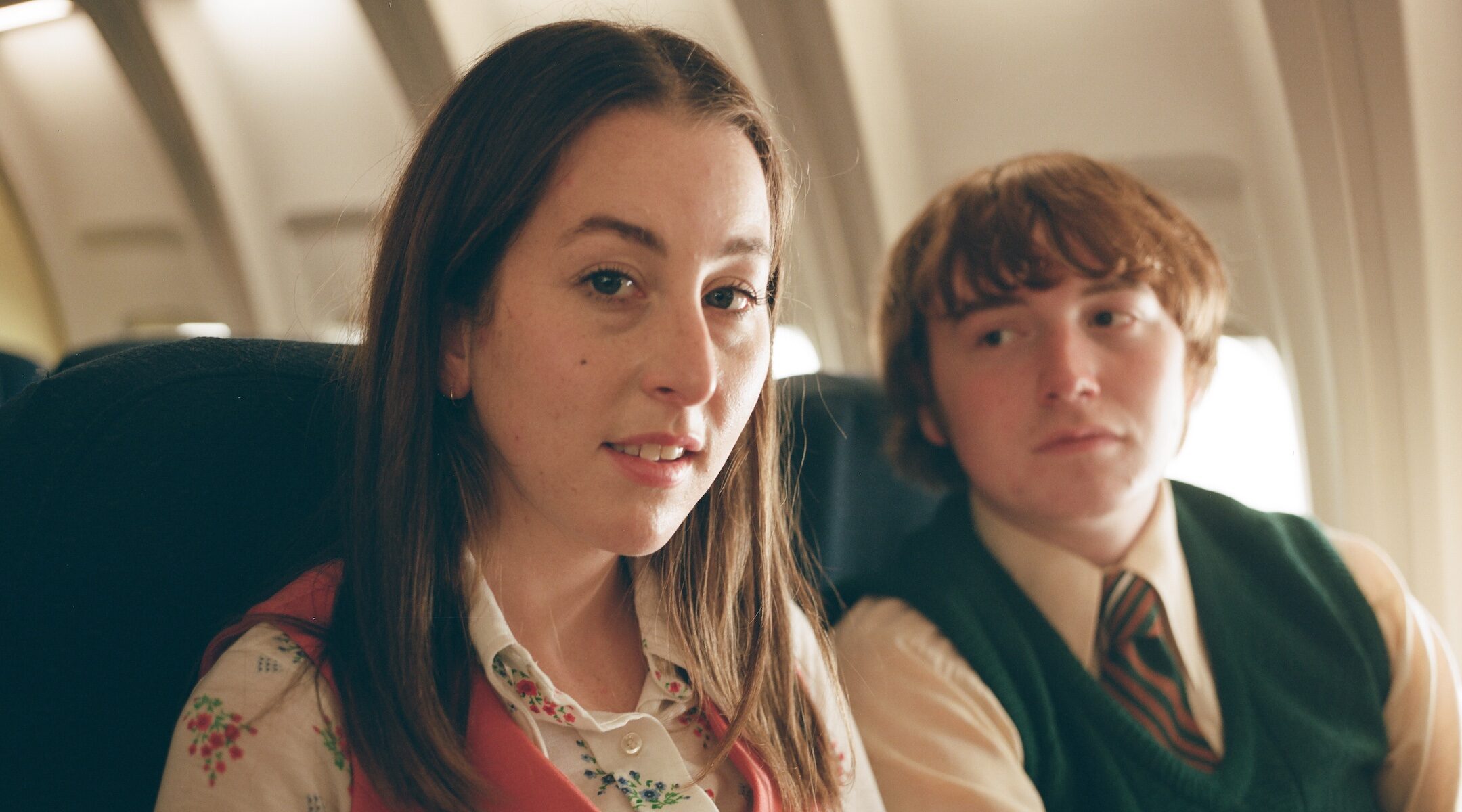 A young women and young man sitting on a plane