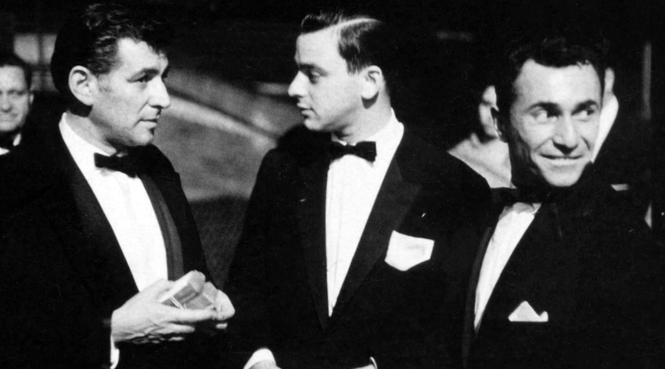 Three men in tuxedos at a Broadway premiere