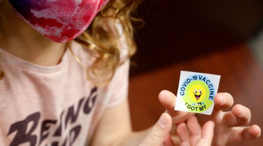 A child holds a sticker she received after getting a COVID-19 vaccine