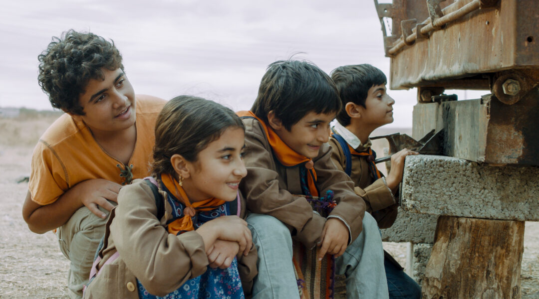 Children crouched behind a wall