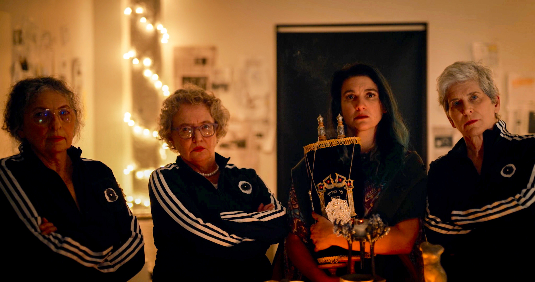 Four women standing with a Torah