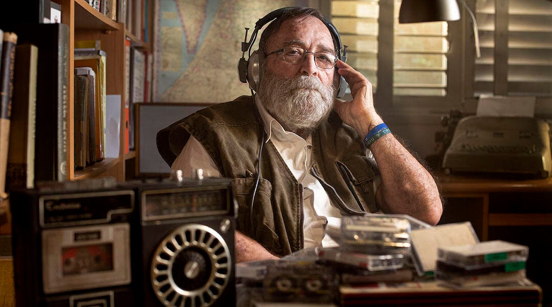 A man listening to a tape recording