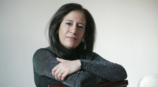 A woman folding her arms sitting on a chair.