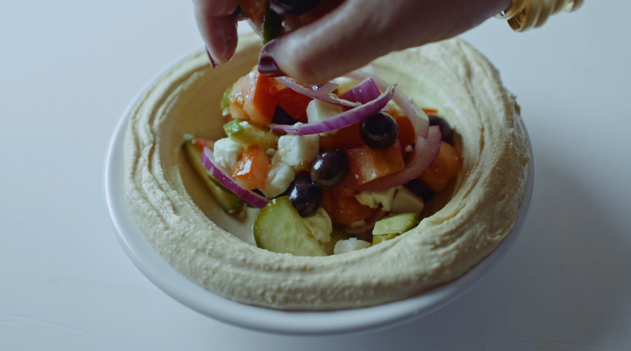 Hummus topped with Greek salad