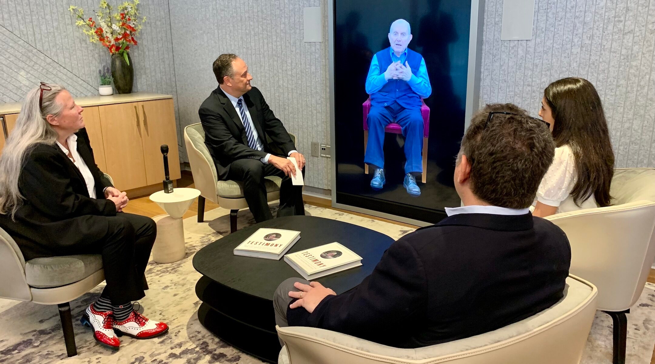 Doug Emhoff speaking to a Holocaust survivor on a screen