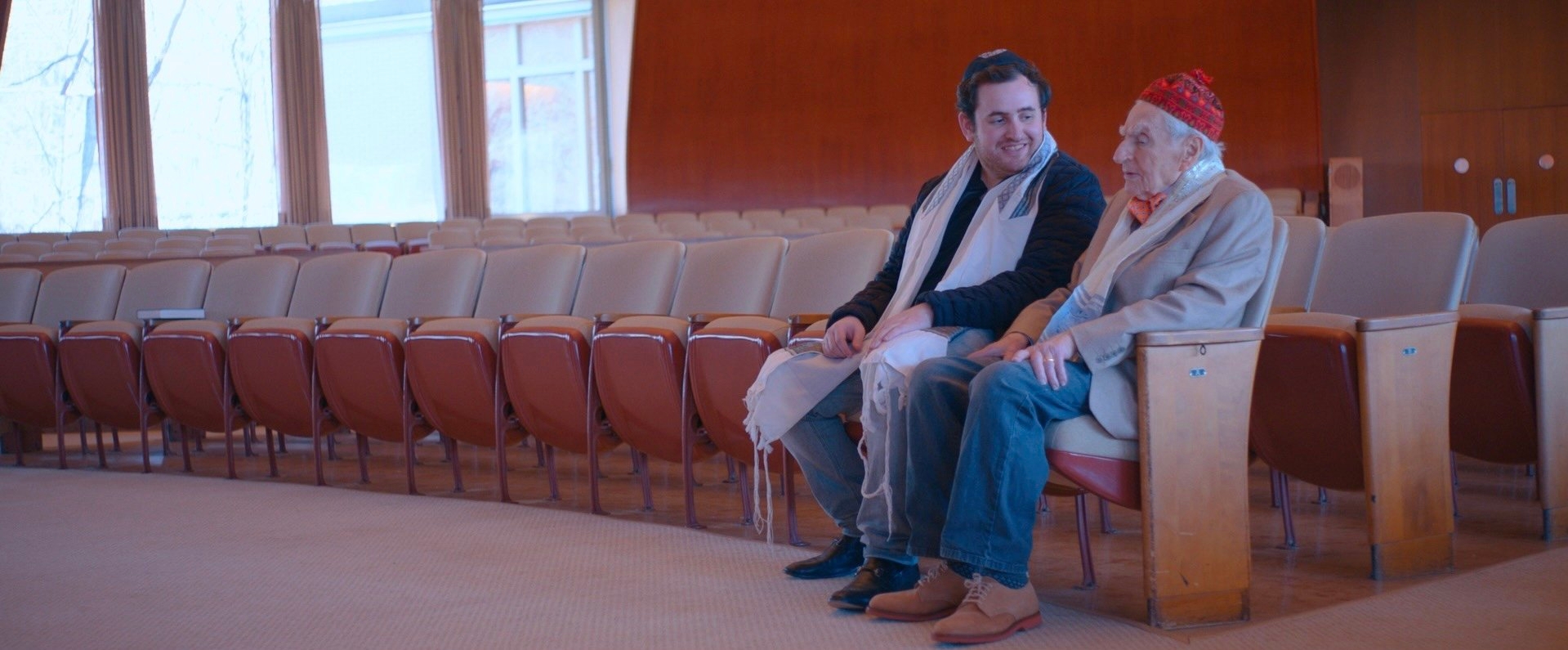 Dr. Howard Tucker and his grandson Austin Tucker, who is making a documentary about his grandfather, talk in synagogue together. (Courtesy “What’s Next?” movie)