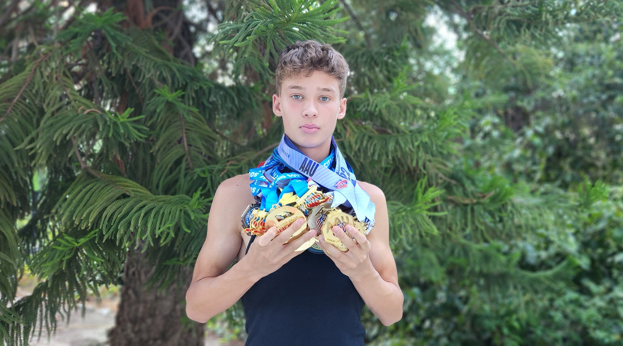 JJ Harel shows off his AAU medals