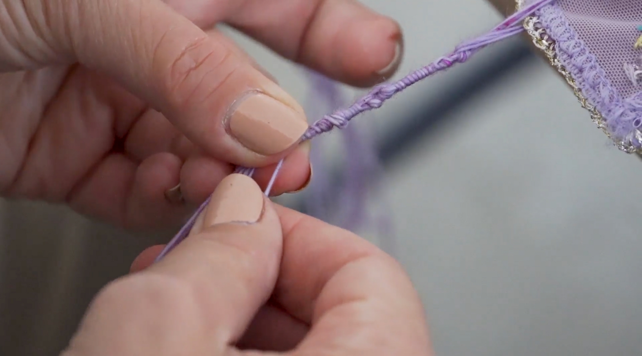 Artist Julie Weitz ties the knots of the tzitzit, fringes attached to the corners of a prayer shawl or the everyday garment known as a “tallit katan.” (Courtesy of Tzitzit Project)