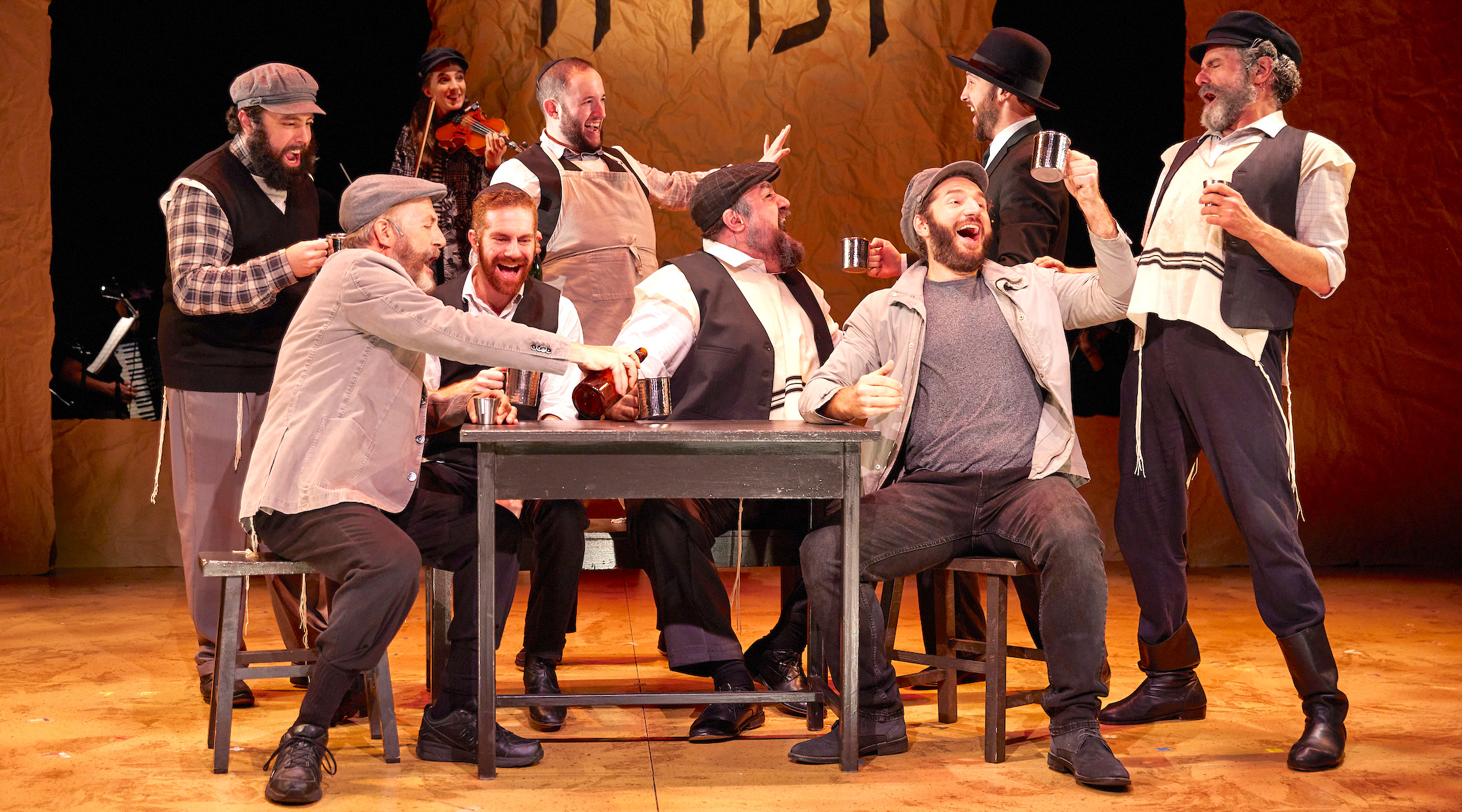 Mikhl Yashinsky, center in gray apron, played Mordkhe the Innkeeper in “Fiddler on the Roof in Yiddish,” the smash hit from the National Yiddish Theatre Folksbiene. (Jeremy Daniel)