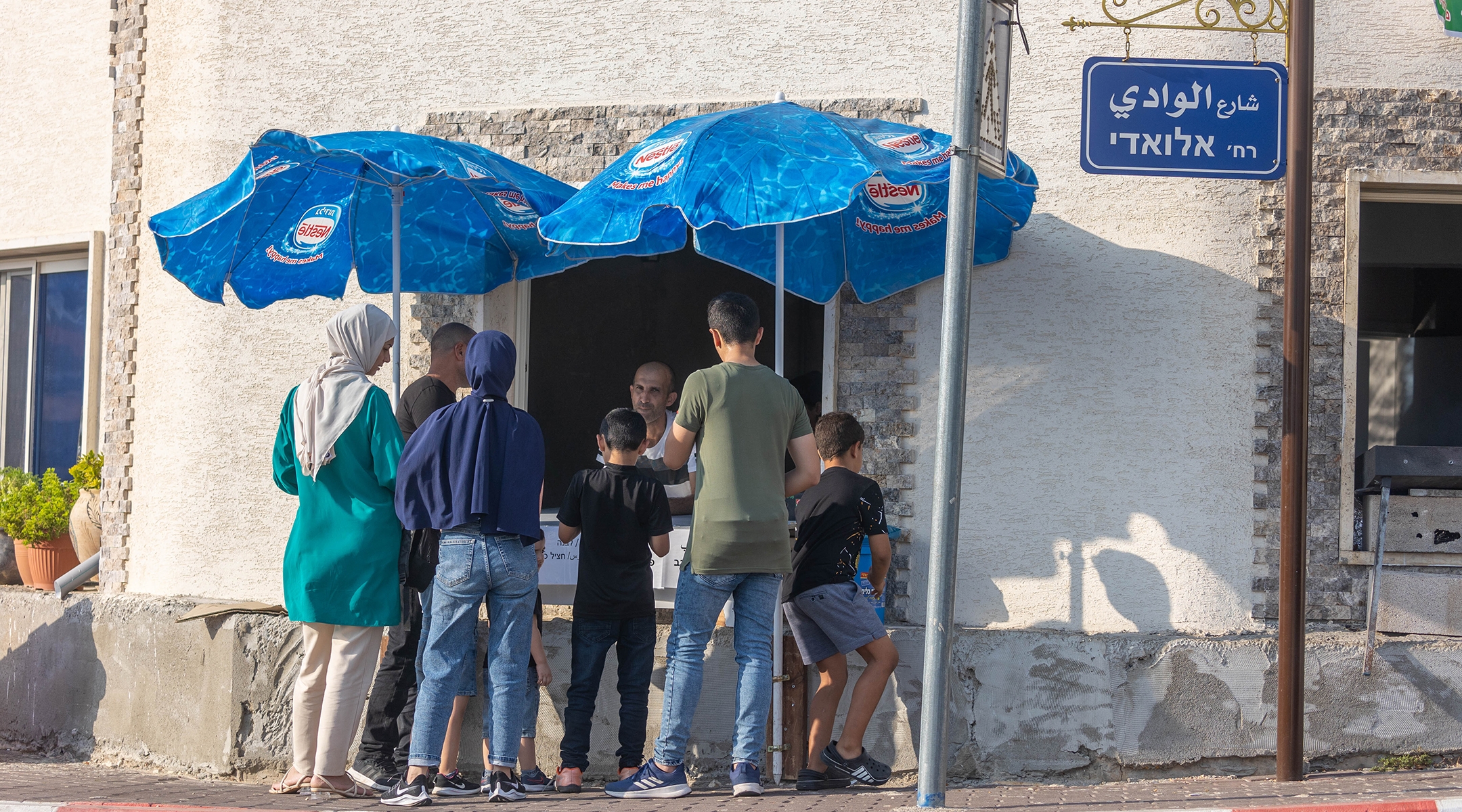 People gather in front of a shop in Ghajar, Oct. 14, 2022. (Yossi Aloni/Flash90)