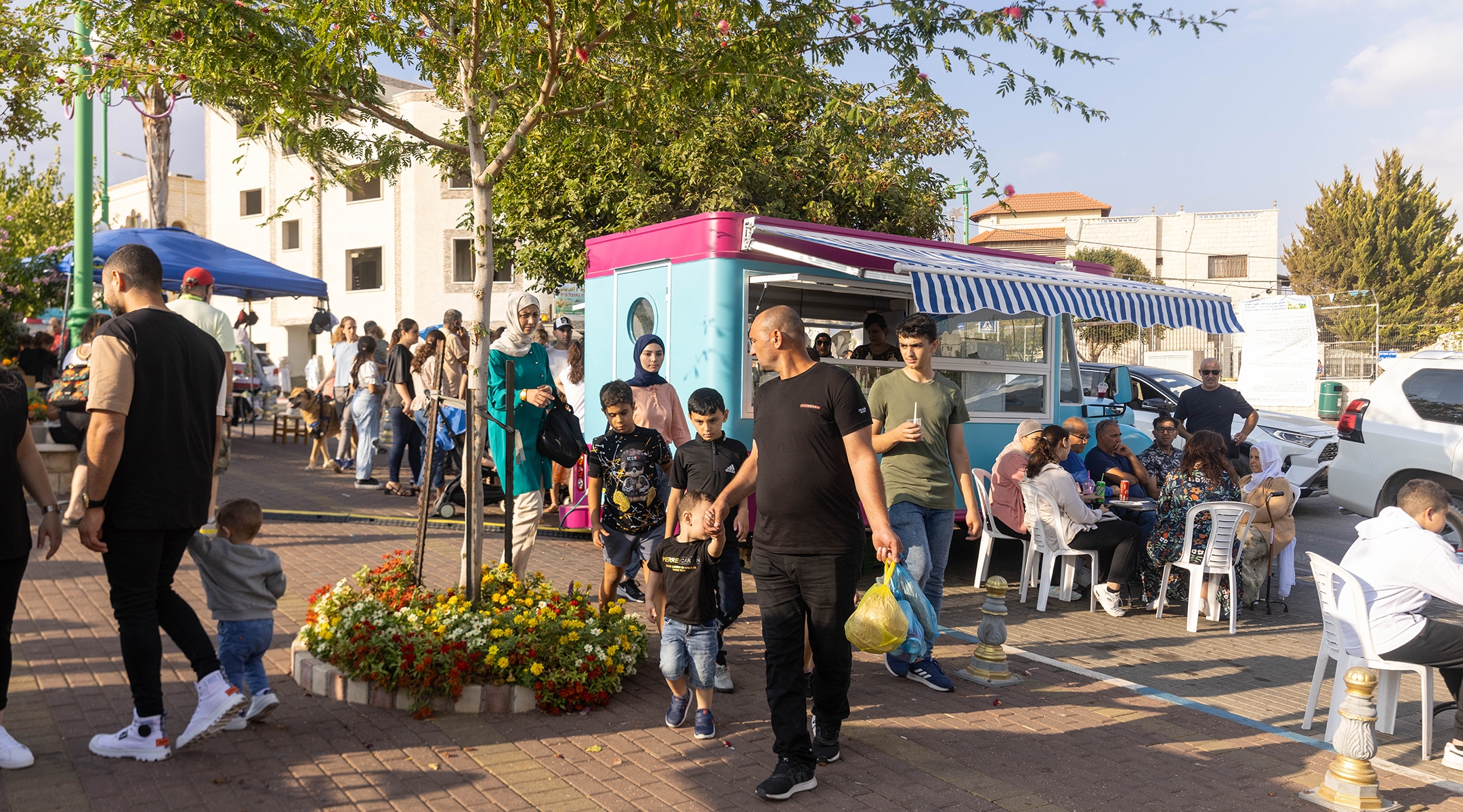 People enjoy a food truck in a plaza in Ghajar, Oct. 14, 2022. (Yossi Aloni/Flash90)