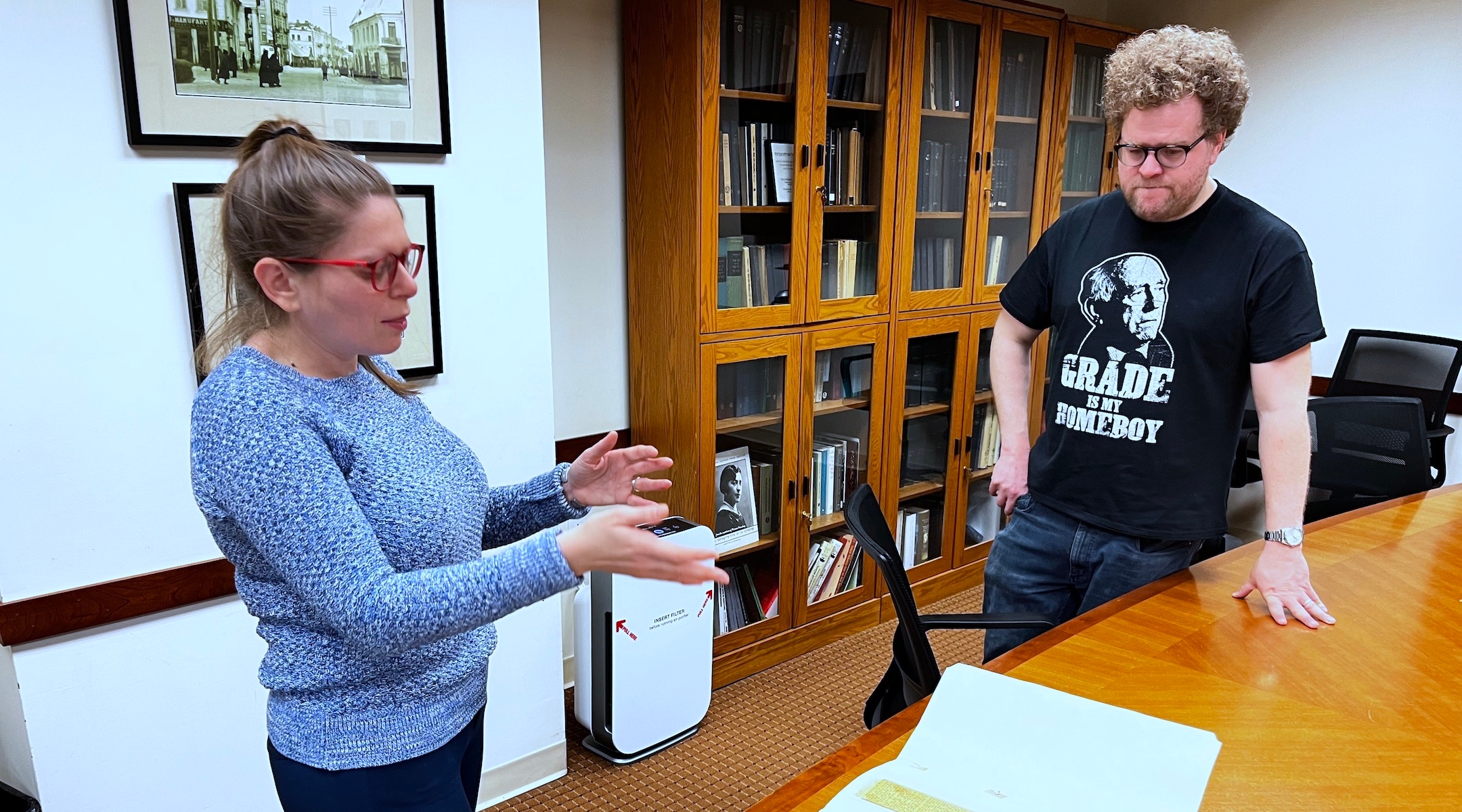 Stefanie Halpern, director of the YIVO archives, and novelist Max Gross discuss a thick file containing news clippings relating to the late Yiddish novelist Chaim Grade at YIVO’s Manhattan offices, Feb. 2, 2023. (New York Jewish Week)