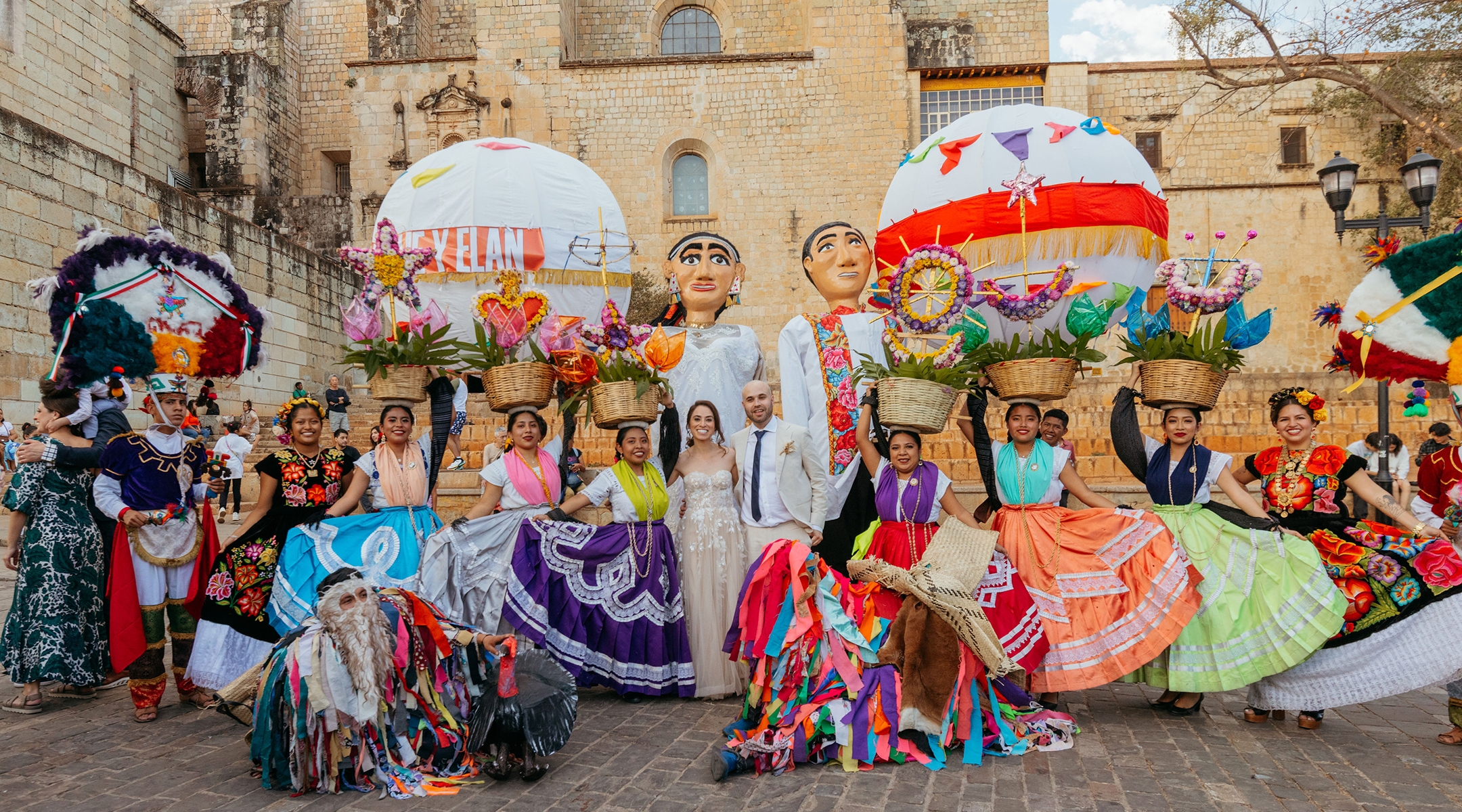 Hallie Applebaum and Evan Raffel pose with dancers who joined their public wedding procession in Oaxaca. (Mónica Godefroy)