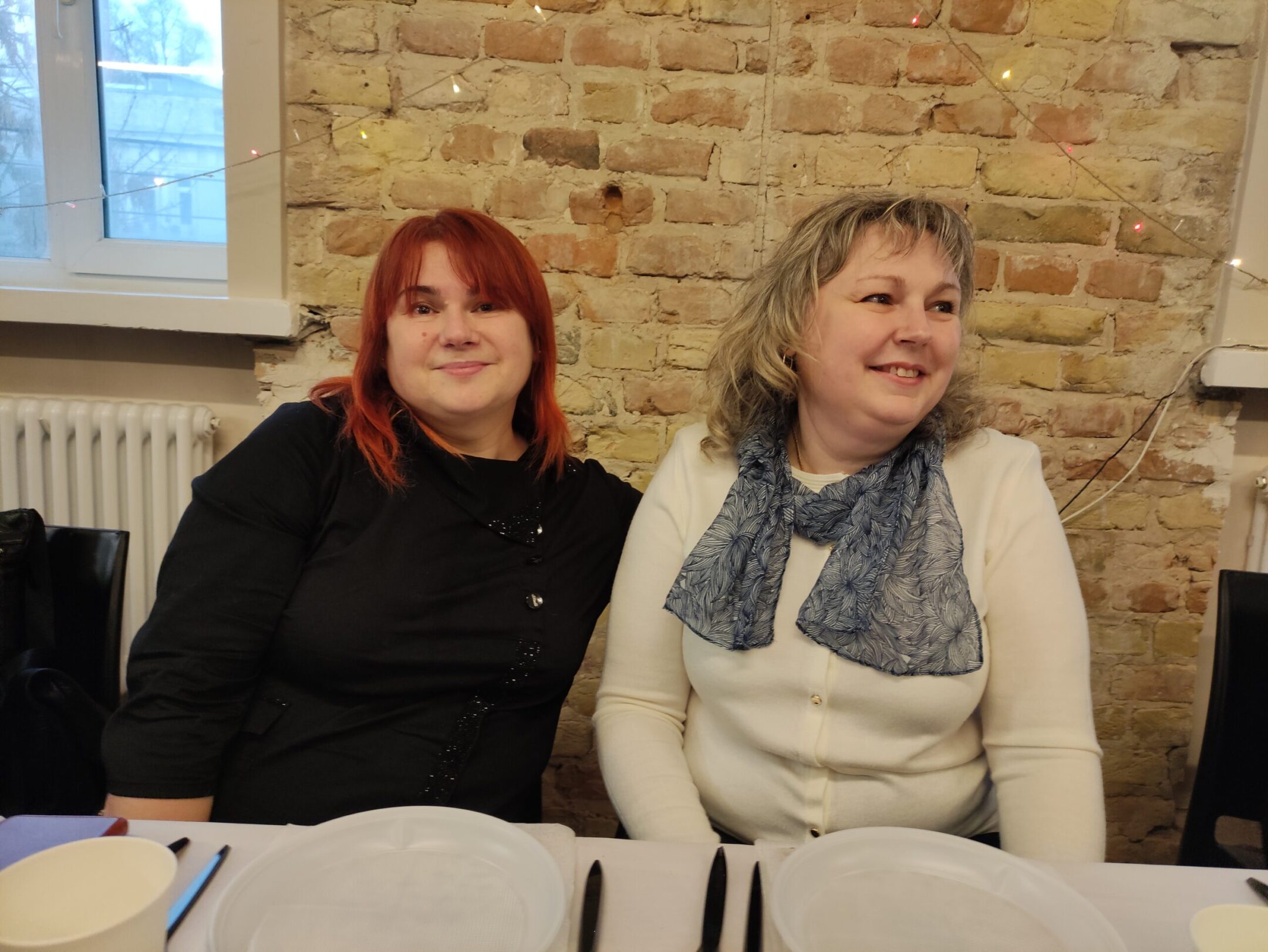 Yuliia Krainiakova, left, and Alla Gusak sit together at a Passover seder in Kyiv, Ukraine, April 5, 2023. (Marcel Gascon Barbera)