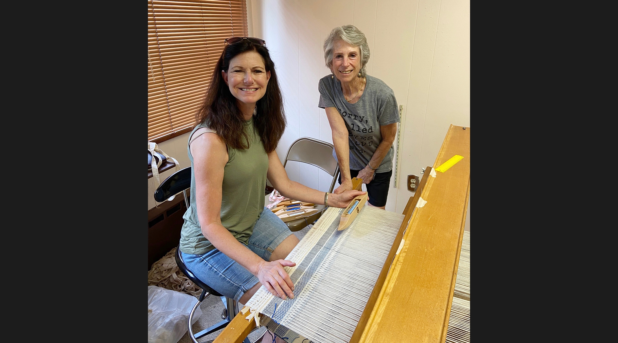 Jennifer Bullock and Cory Schneider weave on the newly-renovated loom that was donated by Deborah Lamensdorf Berman. (Congregation Neve Shalom)