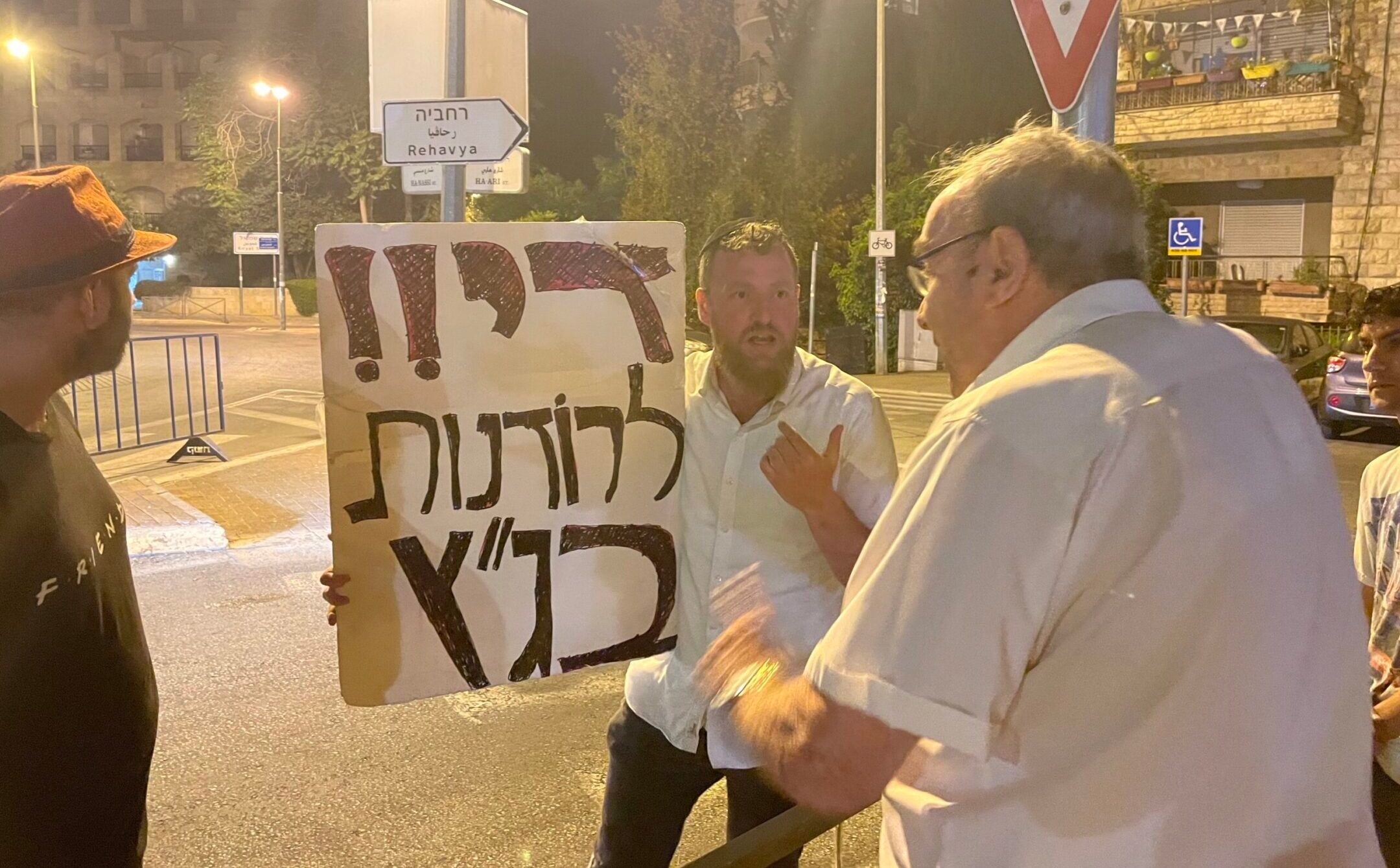 A supporter of proposed judicial reforms in Israel debates an opponent on the streets of Jerusalem, July 5, 2023. (Philissa Cramer)