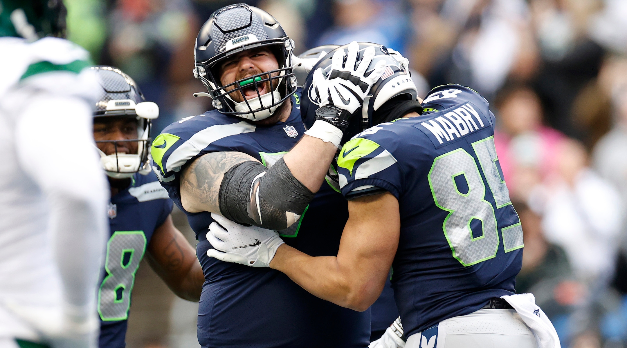 Jake Curhan, center, and Tyler Mabry celebrate after a touchdown at Lumen Field in Seattle, Jan. 1, 2023. (Steph Chambers/Getty Images)