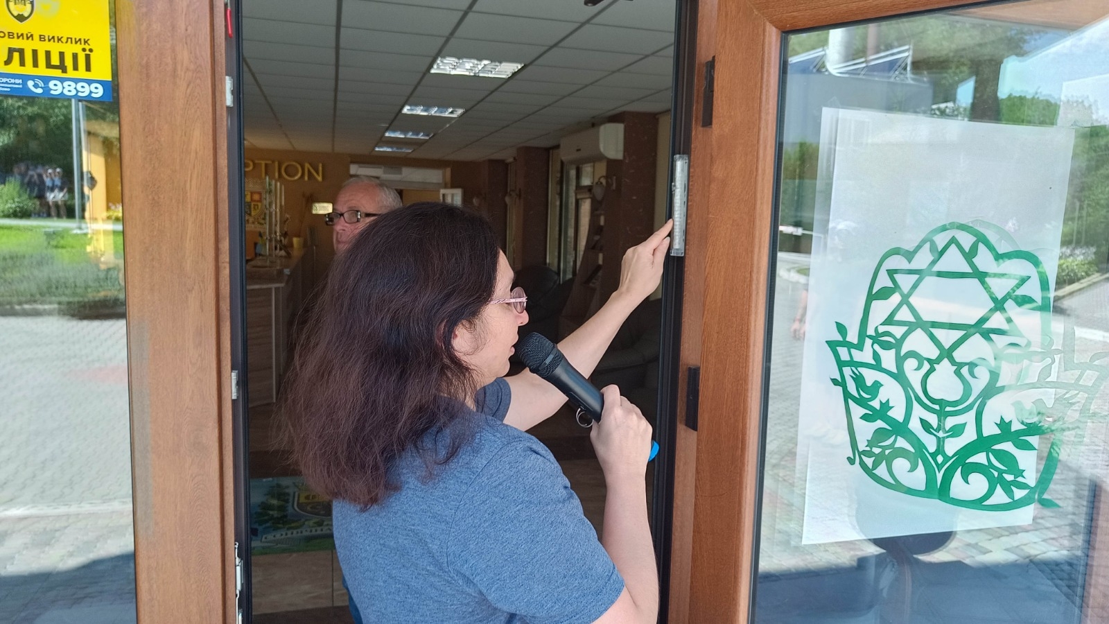 Rabbi Irina Gritsevskaya affixes a mezuzah to a building at Ramah Yachad in Ukraine at the start of the 2023 session. (Courtesy Midreshet Schechter)