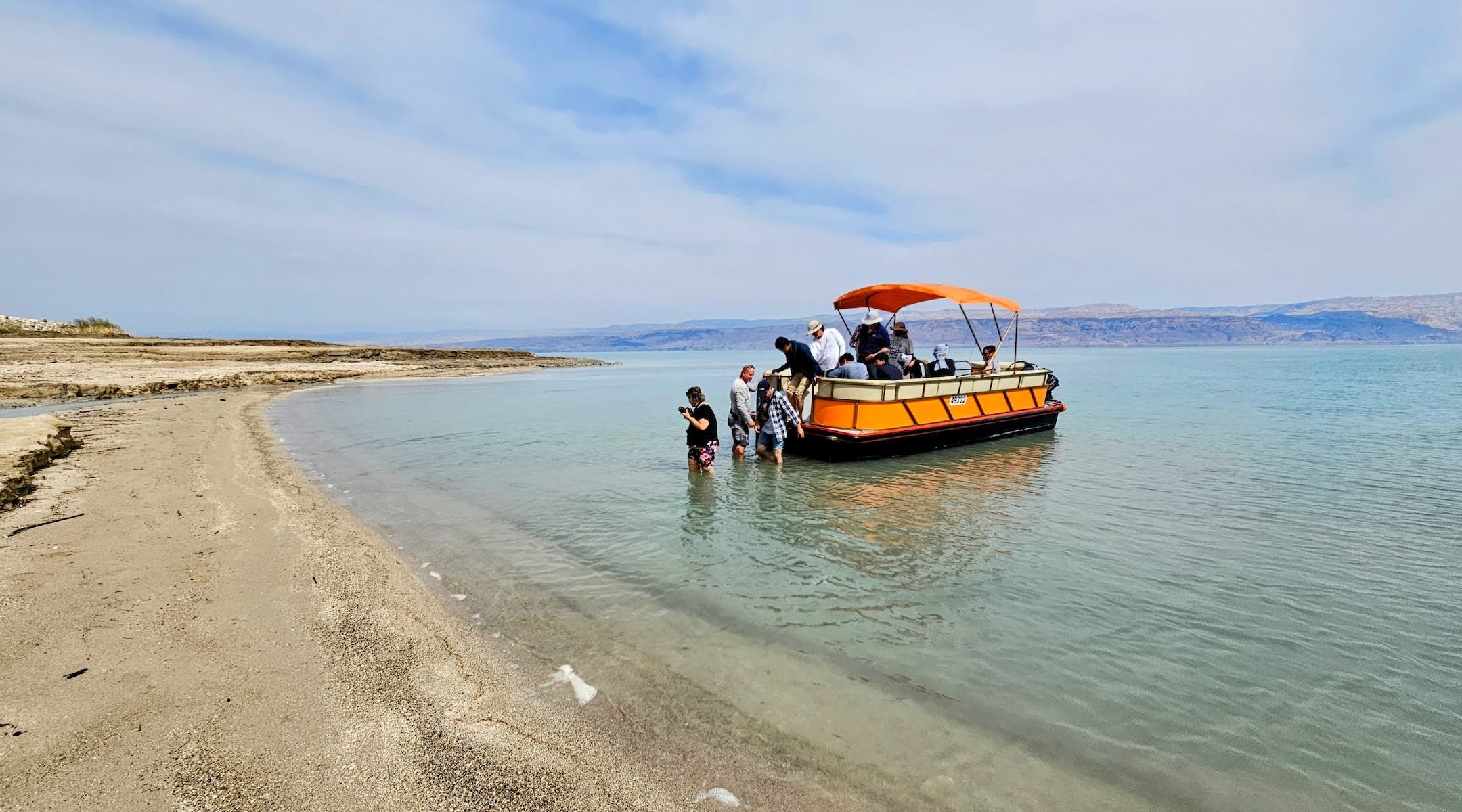 Passengers wade into the waters of the Dead Sea from Noam Bedein's boat on a recent excursion. (Noam Bedein)