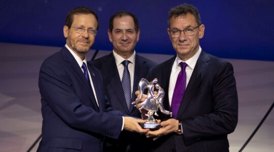 Stan Polovets, center, with Israeli President Isaac Herzog, left, presenting the 2022 Genesis Prize to Pfizer Chairman and CEO Albert Bourla, right, one stage at award ceremony.