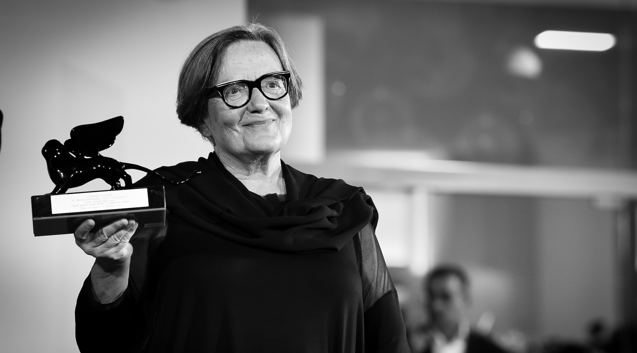 A woman holding a trophy at a film festival