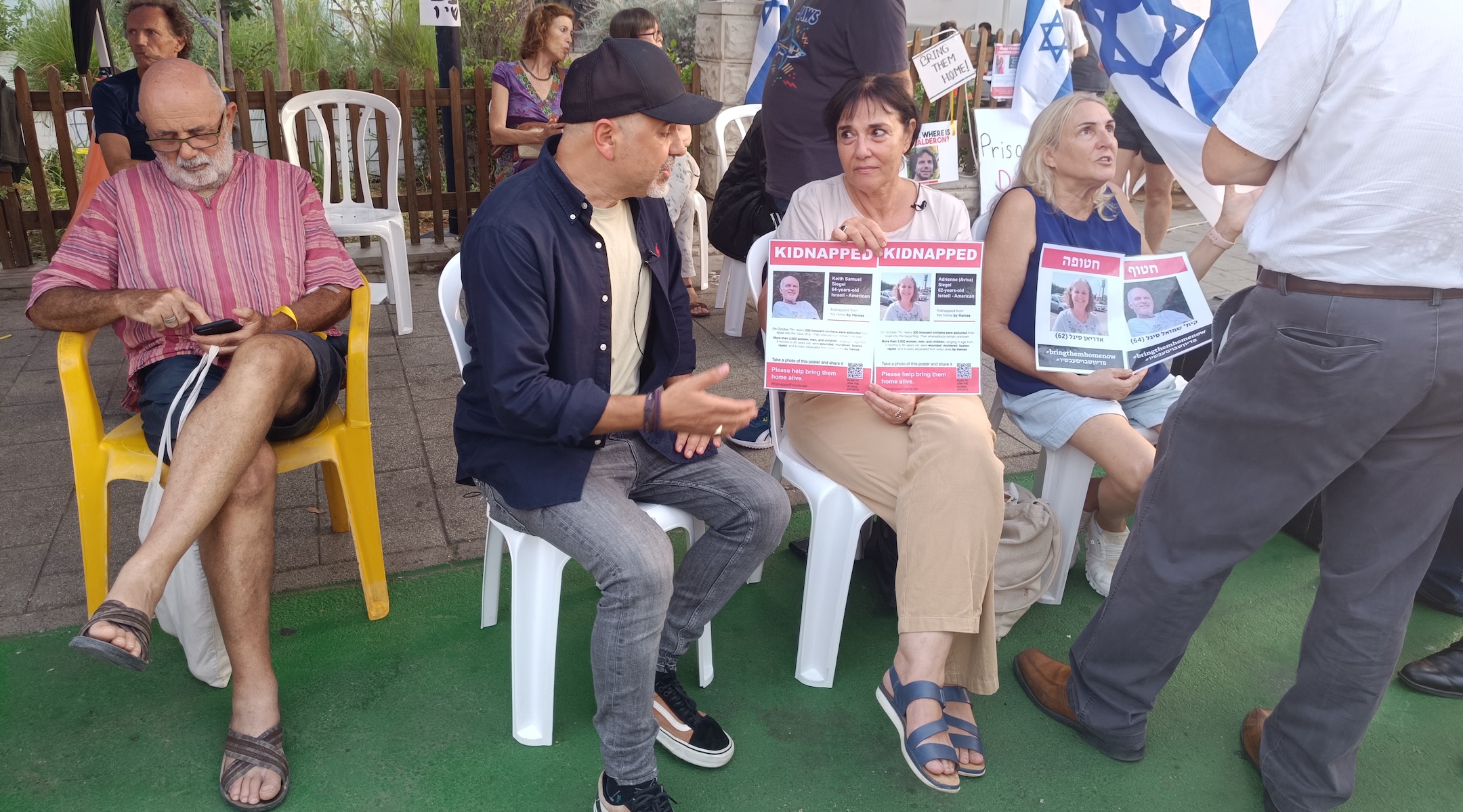 Protesters sit at a protest tent in Tel Aviv erected to draw attention to the hostages held by Hamas in Gaza. (Eliyahu Freedman)