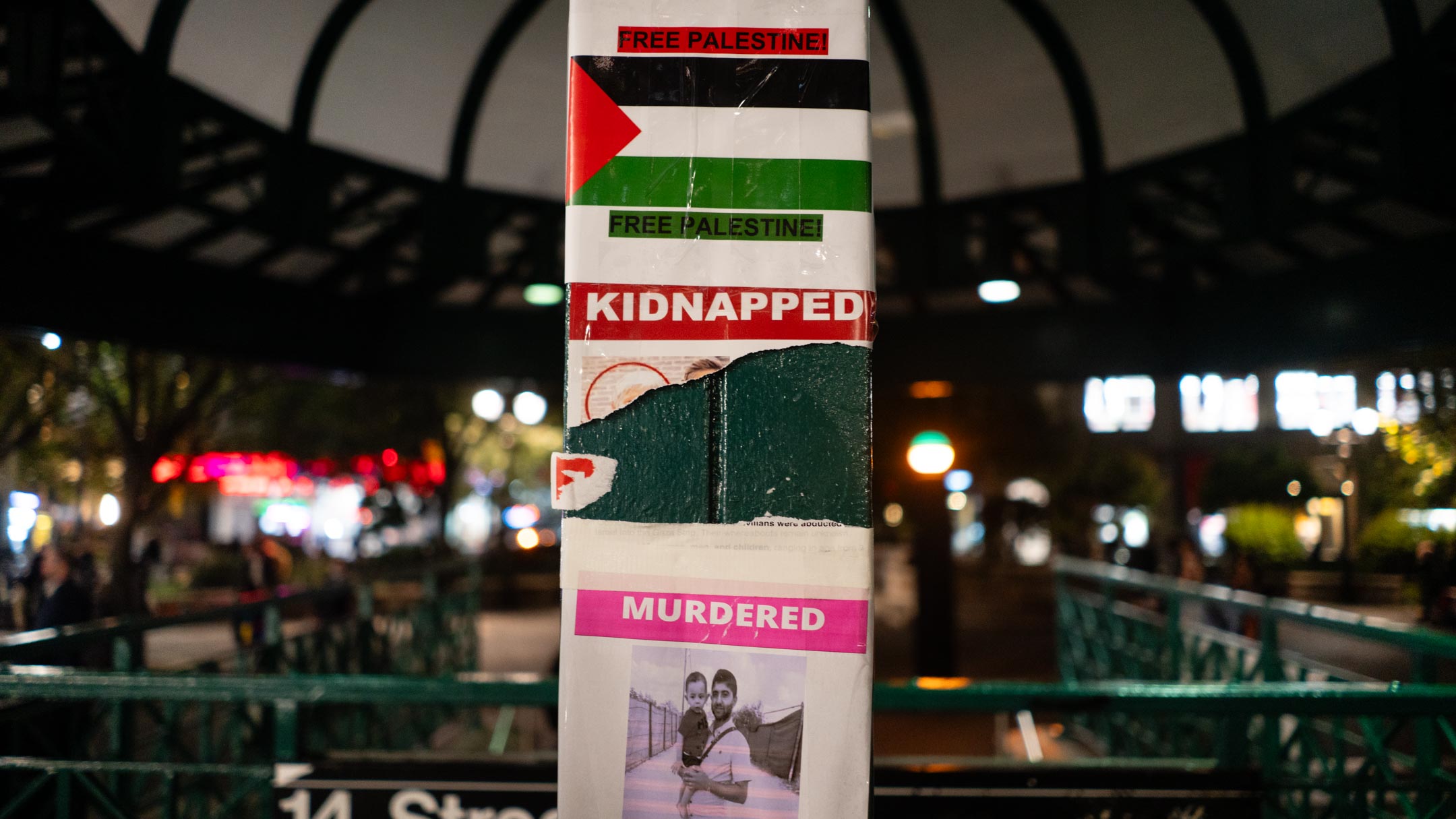 A torn poster about Israeli hostages surrounded by pro-Palestinian messages in New York City's Union Square, October 16, 2023. (Luke Tress)