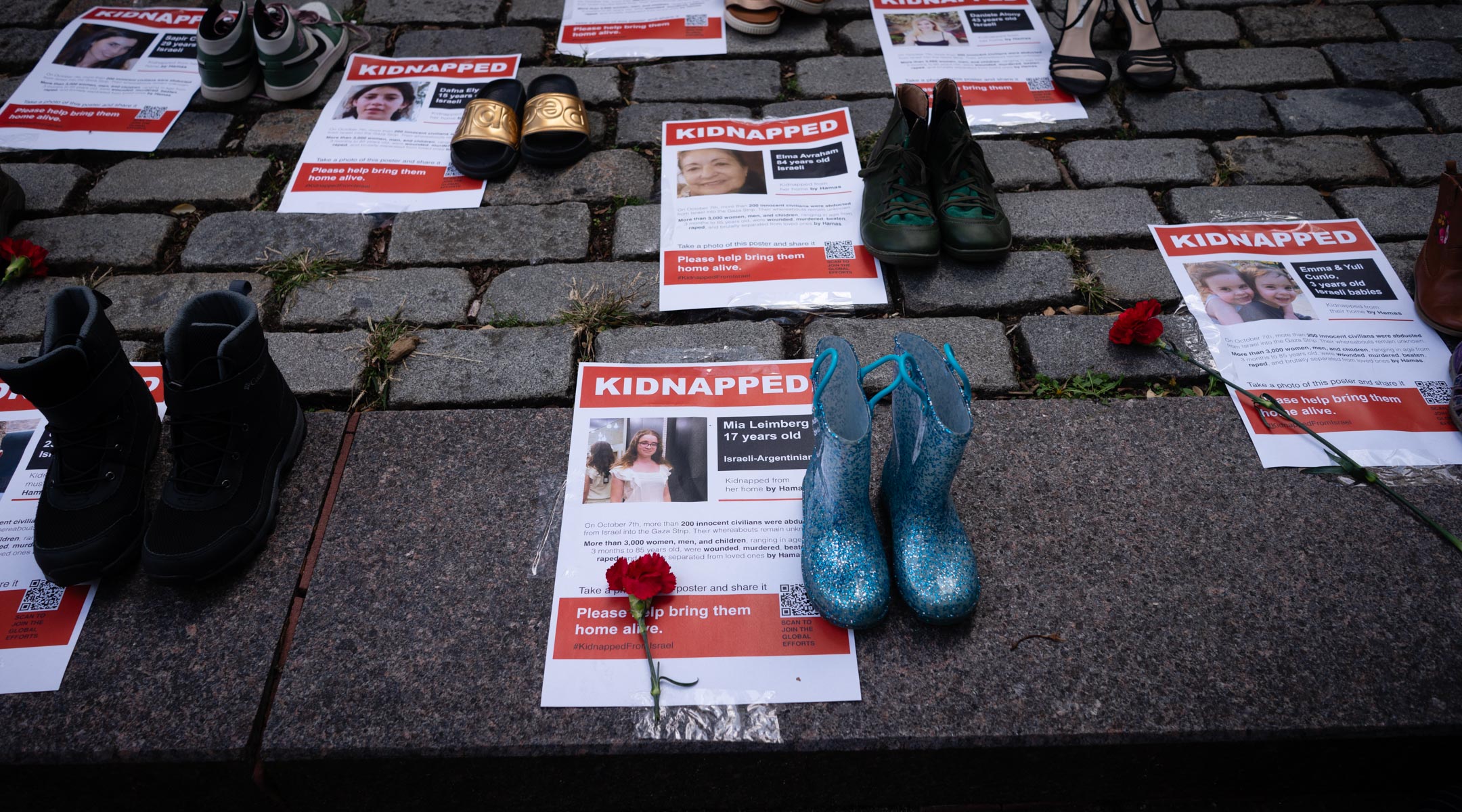 Photos display images of Hamas captives during a rally outside the United Nations, October 24, 2023. (Luke Tress)