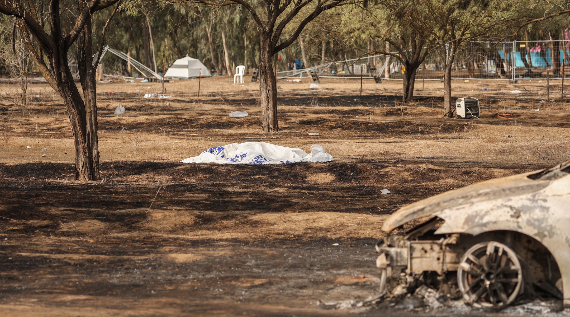 A dead body on the grounds of the Tribe of Nova music festival after Saturday's deadly attack by Hamas. (Ilia Yefimovich/picture alliance via Getty Images)