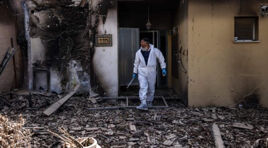 A haredi volunteer for the Zaka emergency response service searches through the debris in Kibbutz Be'eri, near the border with Gaza, on October 20, 2023. (Ronaldo Schemidt/AFP via Getty Images)