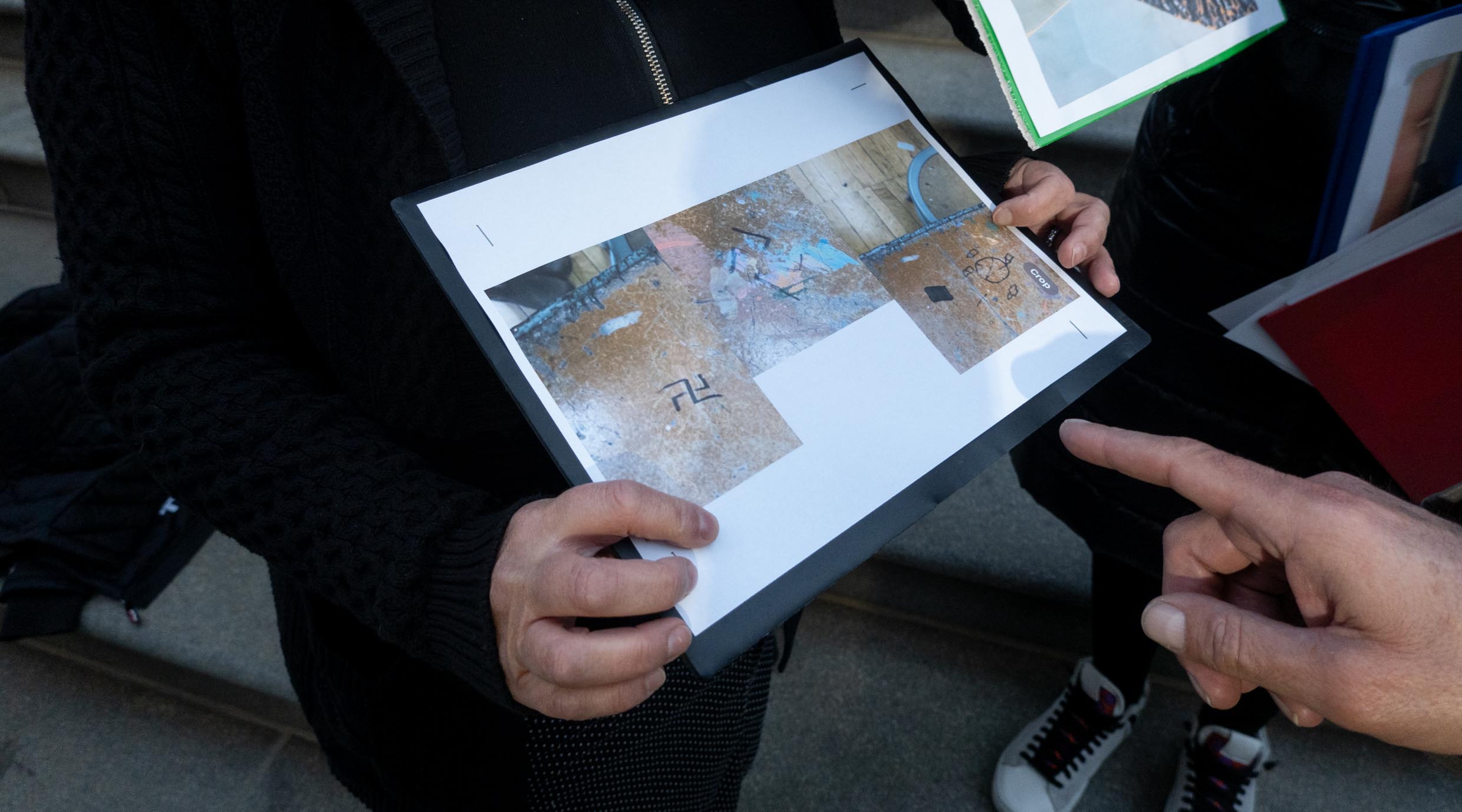 New York City public school educators hold photos of swastikas found on school grounds, at a rally demanding action against antisemitism from Chancellor David Banks in New York City, November 28, 2023. (Luke Tress)